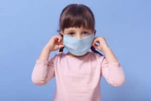worried-girl-with-dark-hair-putting-her-face-medical-respirator-mask