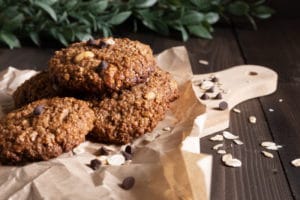 homemade-oatmeal-cookies-with-chocolate-nuts-baking-paper-wooden-cutting-board