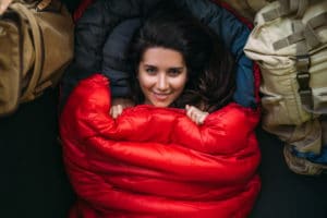portrait-young-woman-who-is-cozy-warm-red-sleeping-bag-cute-tourist-girl-with-red-sleeping-bag-tent-camping-travel-woman-resting-sleeping-bag-hiking-outdoor-recreation