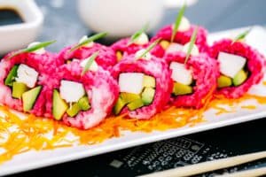 close-up-pink-sushi-rolls-with-crab-sticks-avocado-bell-pepper_141793-2300